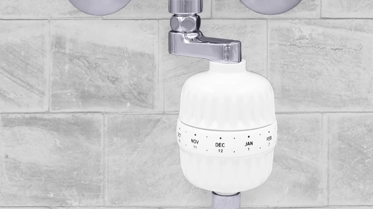 Filtre de douche Hydropure Classic vissé sous un mitigeur mural, relié au flexible de douche