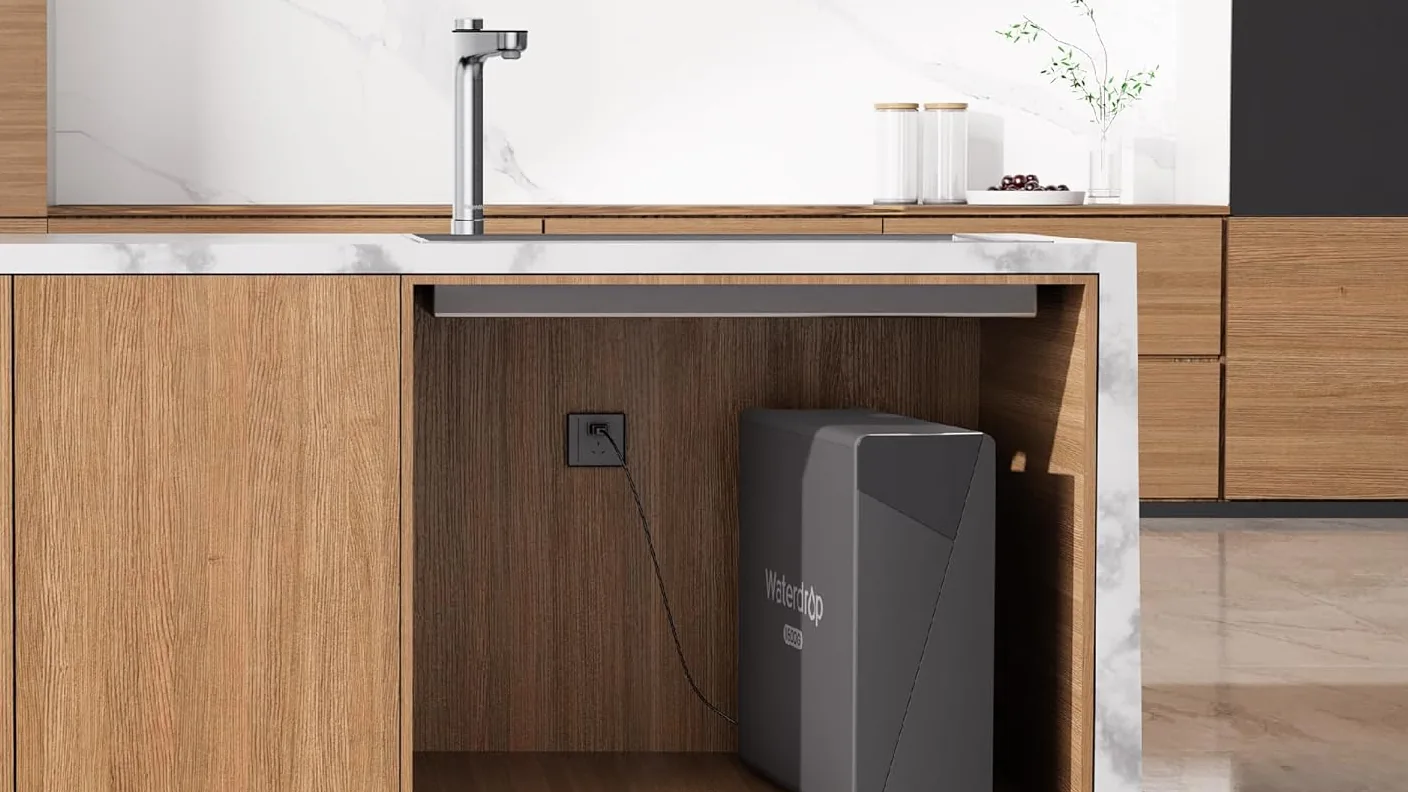 Osmoseur Waterdrop X16 installé sous l'évier d'une cuisine en bois, avec son robinet intelligent sur le plan de travail